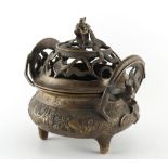 A Chinese ornate bronze censer, the pierced cover with dragon finial, 8.7ins. (22cms.) across (