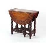 Property of a gentleman - an early 20th century carved oak oval topped gate-leg table with
