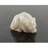 Property of a lady - a Chinese carved white jade model of a recumbent mythical lion cub, probably