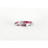 A platinum ruby & diamond eternity ring, with pairs of round brilliant cut diamonds alternating with