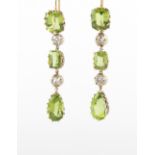 A good pair of peridot & diamond pendant earrings, for pierced ears, each with three cut peridots