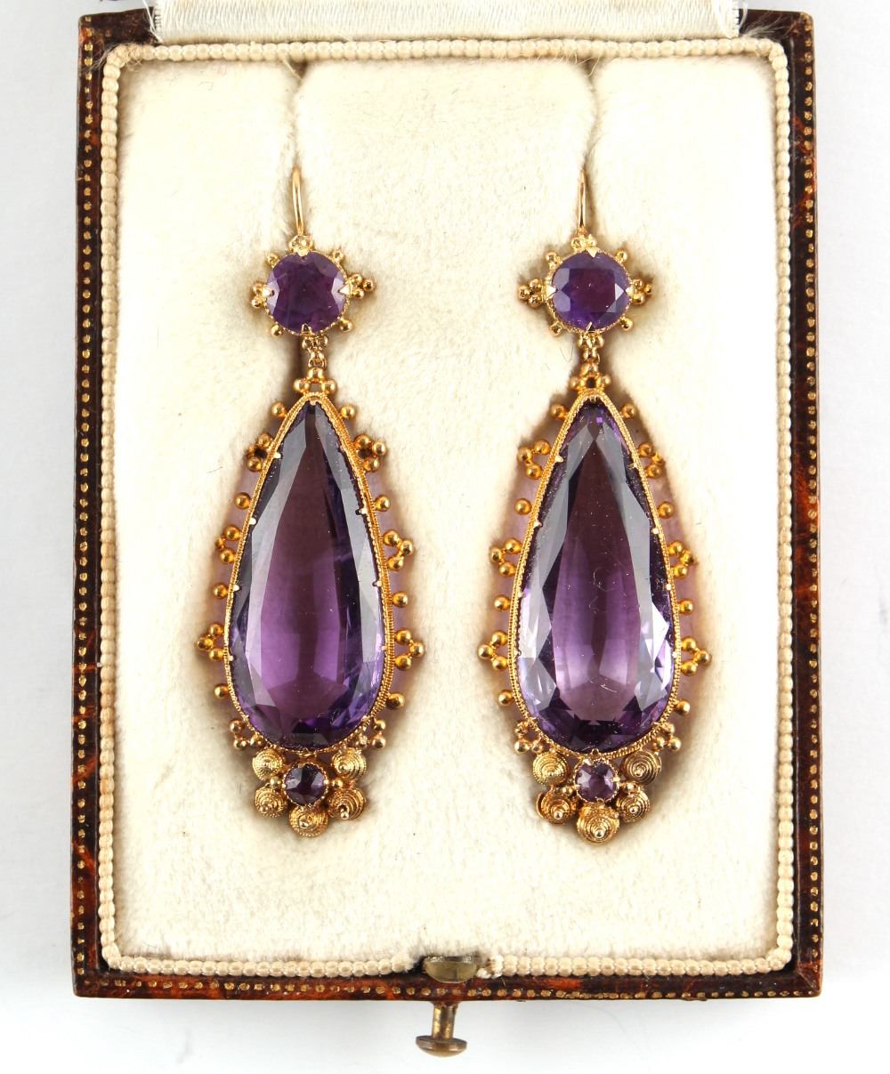 A good pair of Georgian cannetille & amethyst pendant earrings, each with a large pear shaped cut