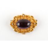 A Victorian unmarked yellow gold (tests 14/15ct) oval brooch set with a large oval cabochon amethyst
