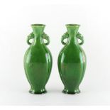 A pair of green glazed vases of slightly flattened baluster form with zoomorphic handles, minor