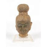 Property of a gentleman - a carved stone Buddha head, South East Asia, mounted on a perspex base,