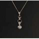 A white gold diamond articulated pendant on 14ct white gold chain necklace, the largest round