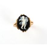 An unmarked yellow gold (tests 18ct) hardstone cameo ring, the oval hardstone carved with a standing