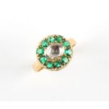 An unmarked yellow gold diamond & emerald cluster ring, the large rose cut diamond measuring