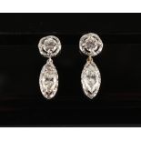A pair of unmarked white gold diamond pendant earrings, with post & butterfly fastenings, each