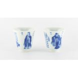 A pair of Chinese blue & white flaring beaker cups, each painted with figures & panels of