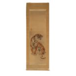 An early 20th century Japanese scroll painting on silk depicting a seated tiger, 2-character