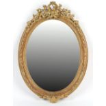 Property of a lady - a late 19th / early 20th century gilt painted oval framed wall mirror, with
