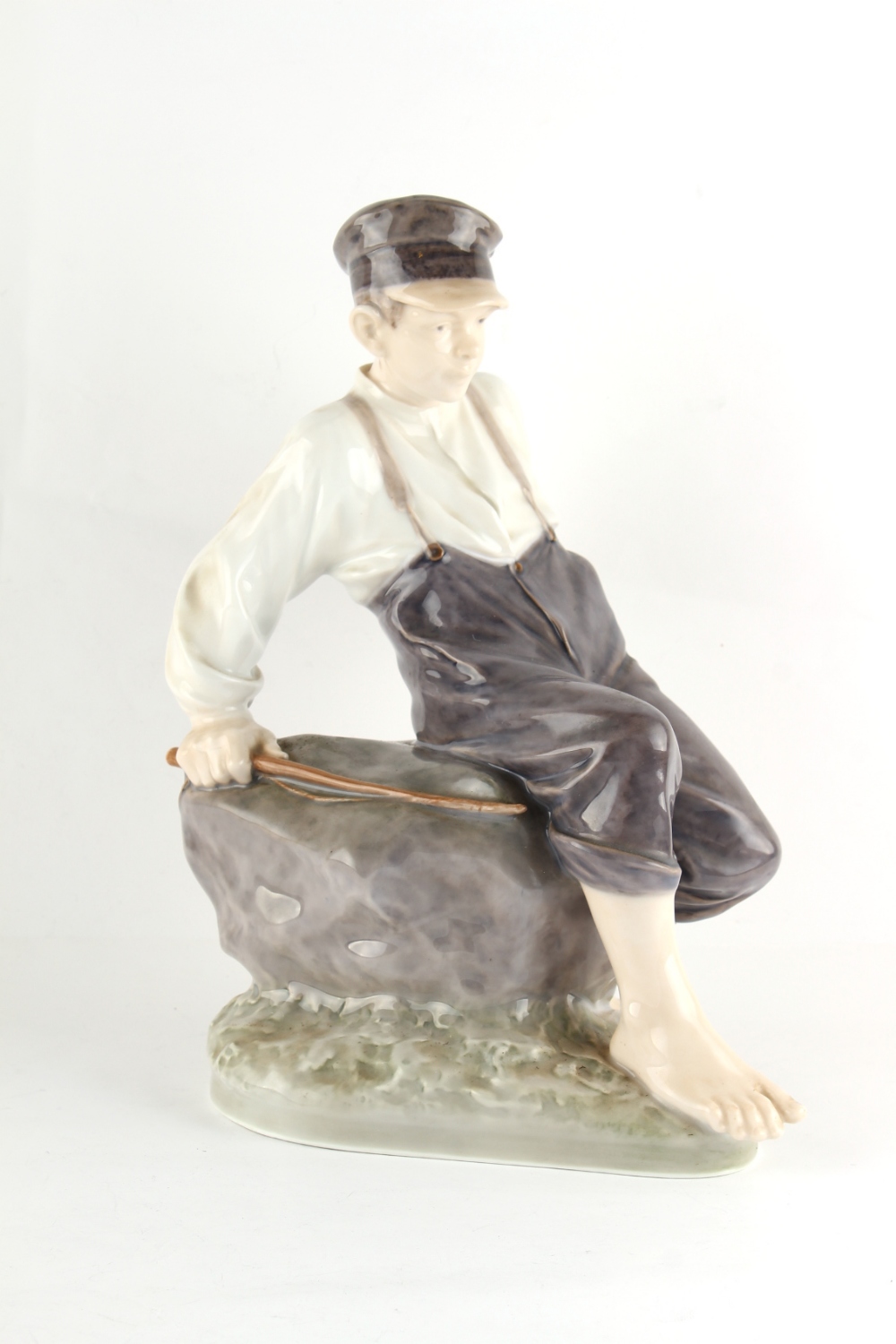 Property of a lady - a large Royal Copenhagen figure of a boy sitting on a rock, model number