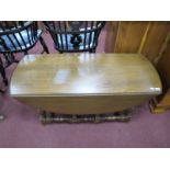 An Ercol Coffee Table, with drop leaves, on turned and block supports.