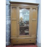 An Early XX Century Oak Wardrobe, with central mirror over long drawer, on turned supports.