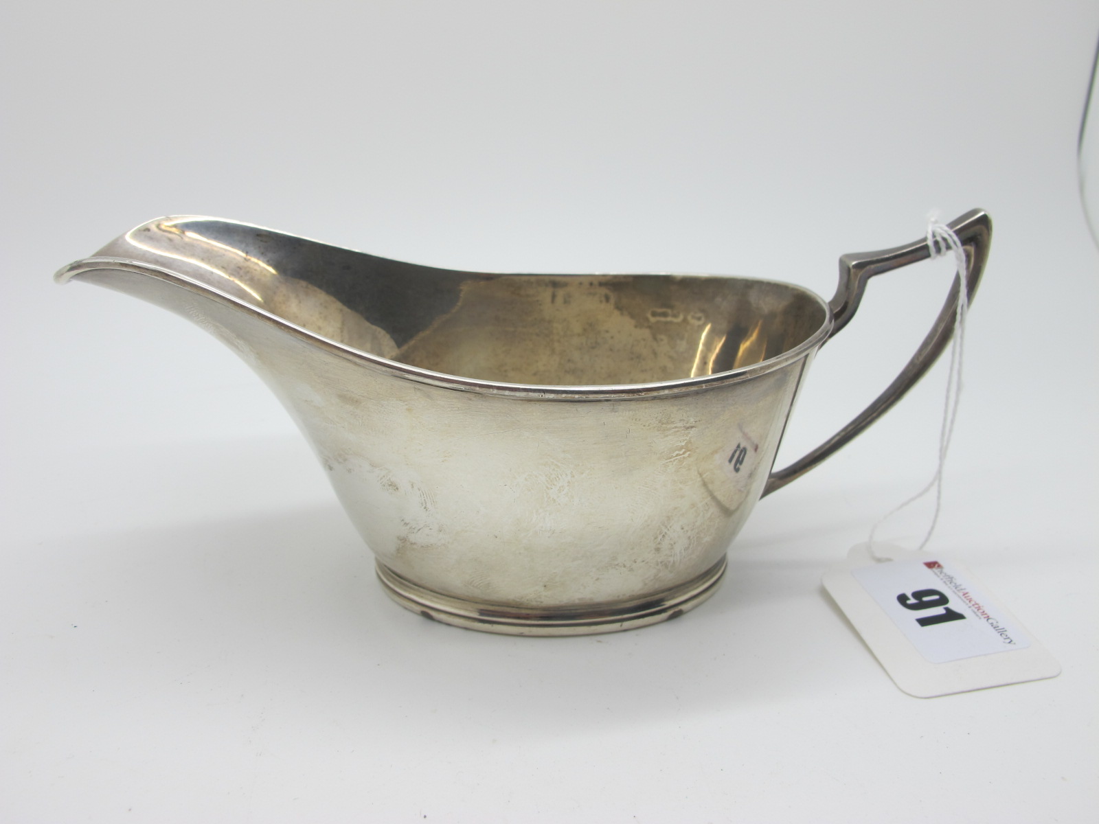 A Hallmarked Silver Sauce Boat, Walker & Hall, Sheffield 1929, of plain design, with pointed loop