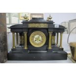 A XIX Century Black Slate Mantle Clock, with brass Corinthian columns and classical scene panels,
