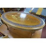 Oval Hardwood Coffee Table, with leaf carved border and all-over brass inlay, 121cm wide.