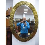 Art Nouveau Oval Bevelled Wall Mirror, with stylized floral decoration to brass frame, 85 x 60cm.