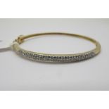 A Modern 9ct Gold Diamond Set Bangle, millegrain set to the front with brilliant cut stones,