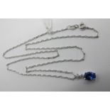 An 18ct White Gold Tanzanite and Diamond Set Pendant, the (7mm) oval tanzanite four claw set below