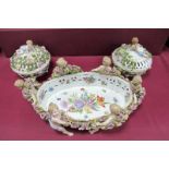 A Late XIX Century German Porcelain Oval Dish, supported by six cherubs entwined with a garland of