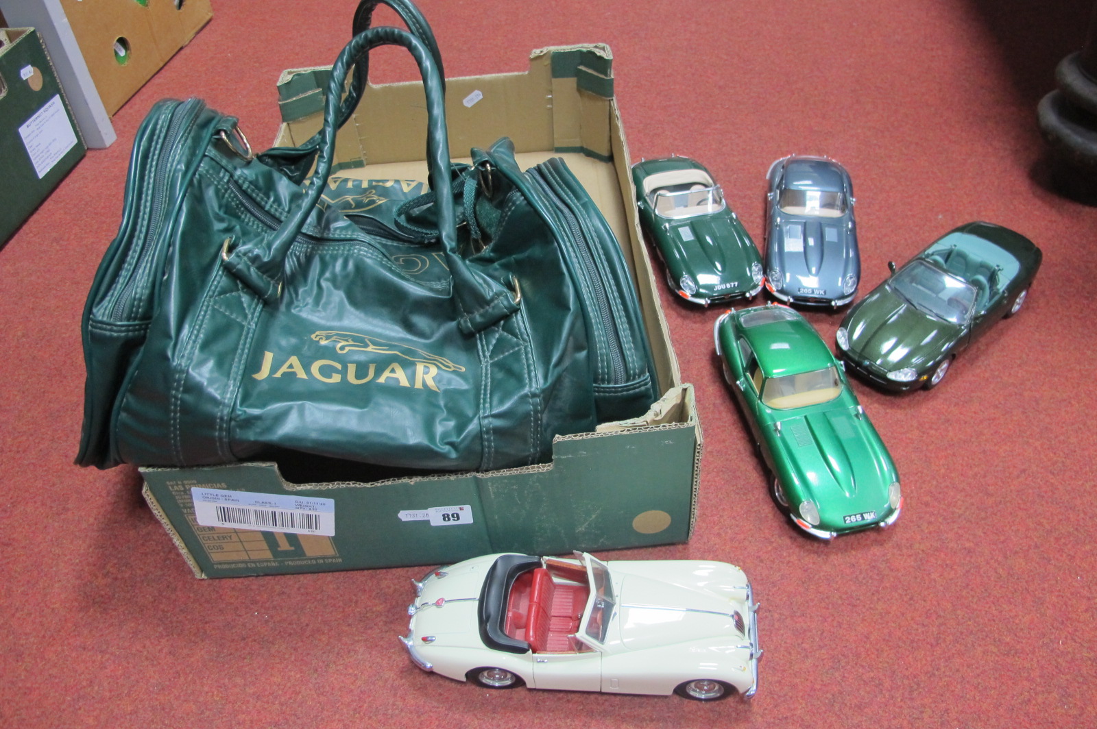 Five 1/18th Scale Model Jaguars, by Burago and others, plus a Jaguar branded bag.