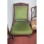 And Edwardian Salon Easy Chair, with mask carving, turned legs, upholstered in green draylon.