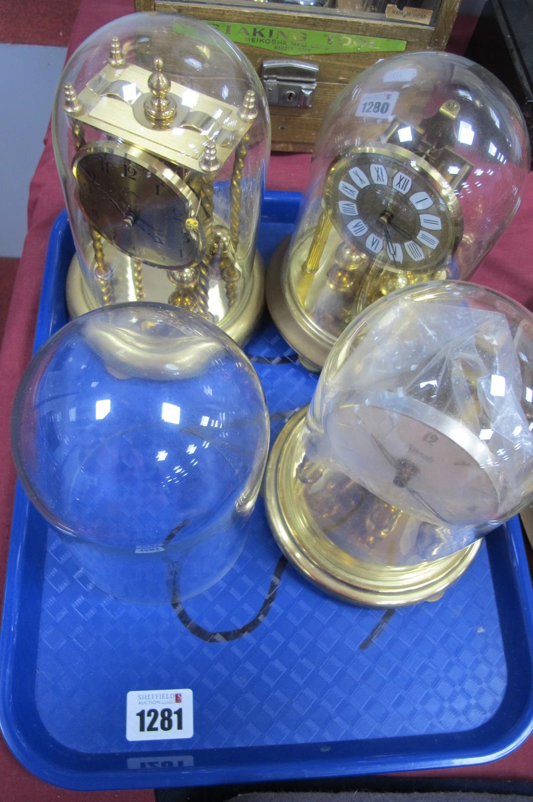 Two Koma and Kundo Clocks, under glass domes and spare dome, 14.5cm high.