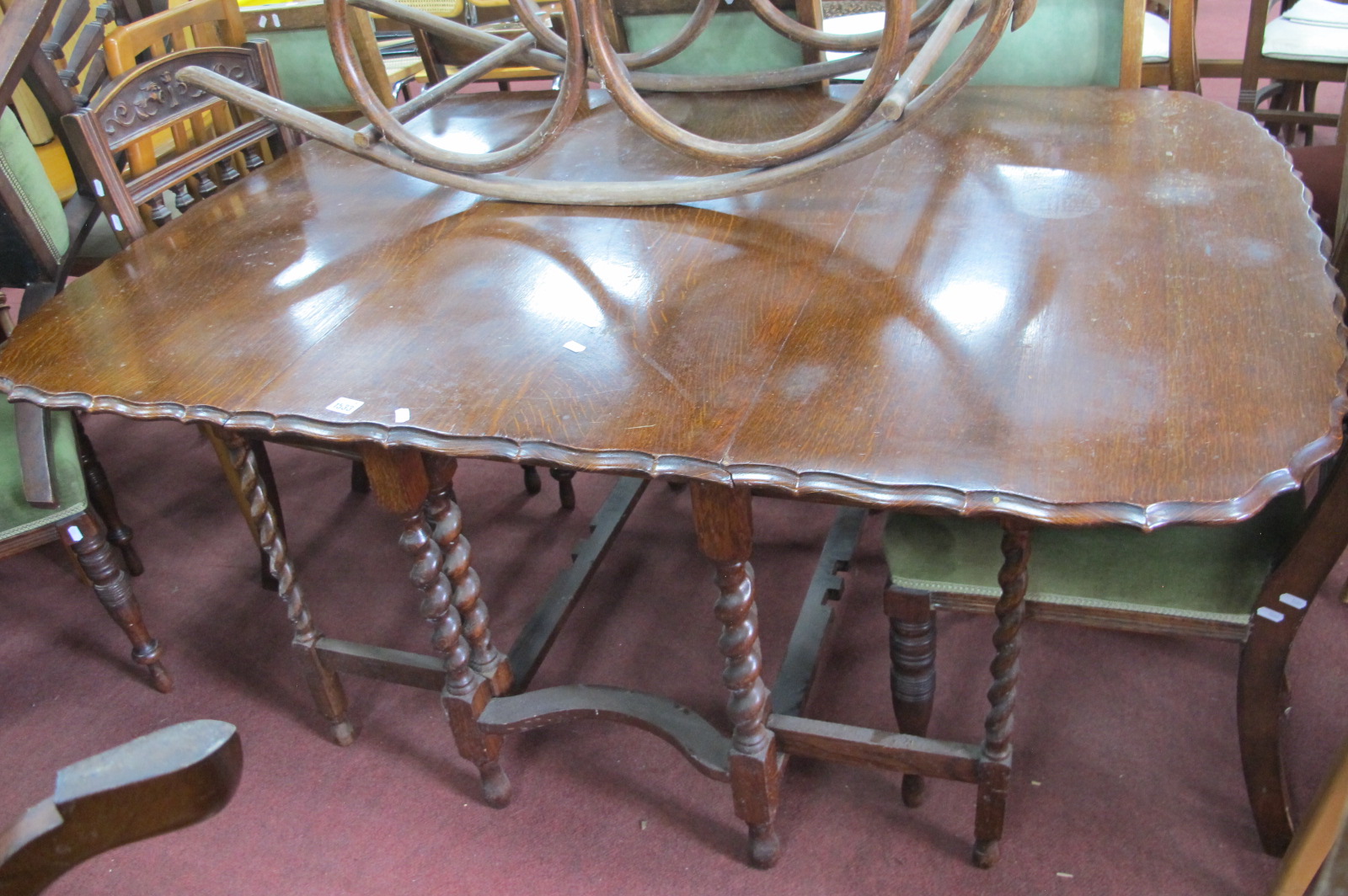 A 1920's Oak Gateleg Dining Table, with wavy border on barley twist supports.