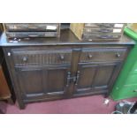 An Ercol Dark Wood Dresser, with knulled drawers over cupboard doors, 131.5cm wide.