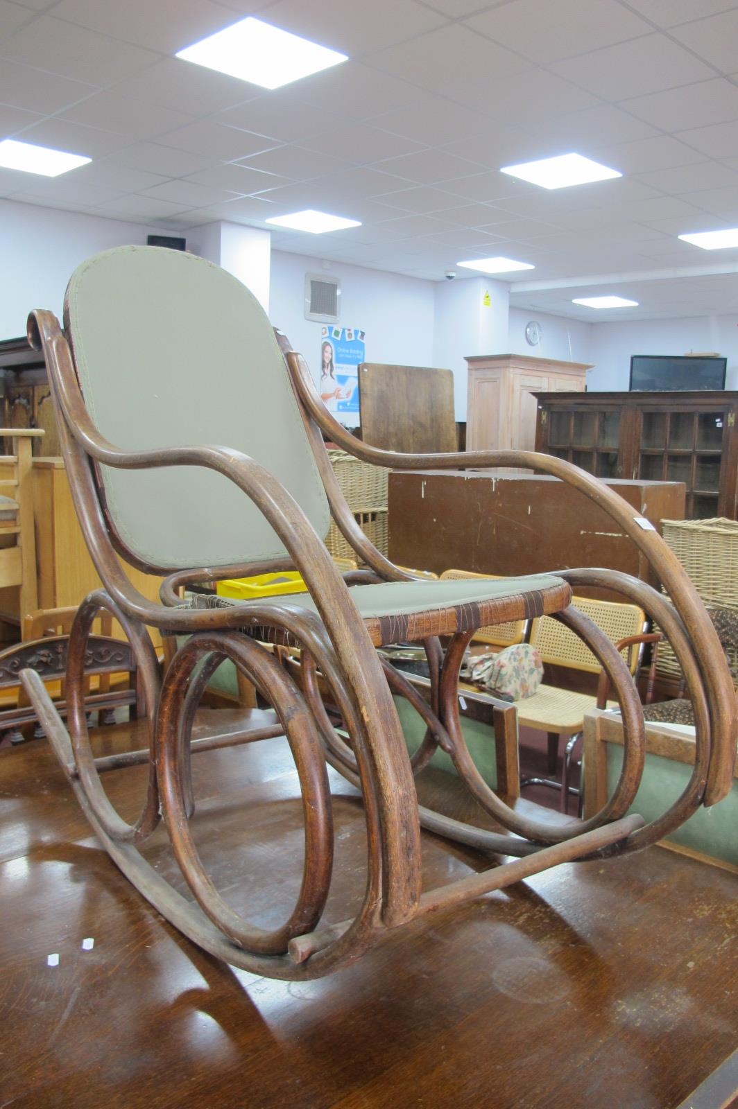 An Early XX Century Bentwood Rocking Chair, with upholsted back panel and seat.