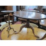 An XVIII Century Mahogany Pedestal Table, with circular top raised on turned pedestal, cabriole legs