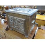 An Early XX Century Oak Coal Box, with a hinged carved top and front panel, on turned feet.