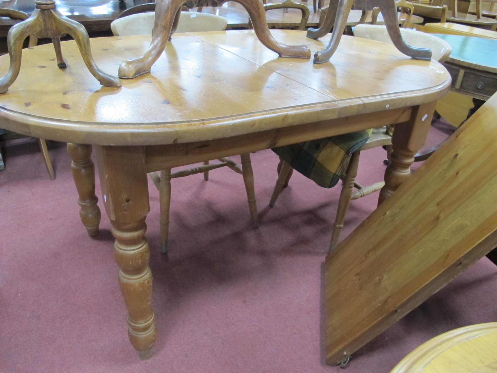 A Pine Oval Shaped Kitchen Table, with extra leaf, on turned legs.