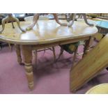 A Pine Oval Shaped Kitchen Table, with extra leaf, on turned legs.