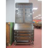 A 1920's Oak Bureau Bookcase, the top with twin leaded glazed doors, with a fall front, fitted