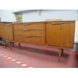 A Beautility Teak Sideboard, with three central drawers and flanking cupboards, on tapering legs