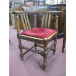 A 1920's Oak Corner Chair with carved cresting. rail and turned back splat's, turned and block