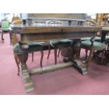 A 1930's Oak Dining Table, the shaped rectangular top with two extra leaves, raised on carved floral