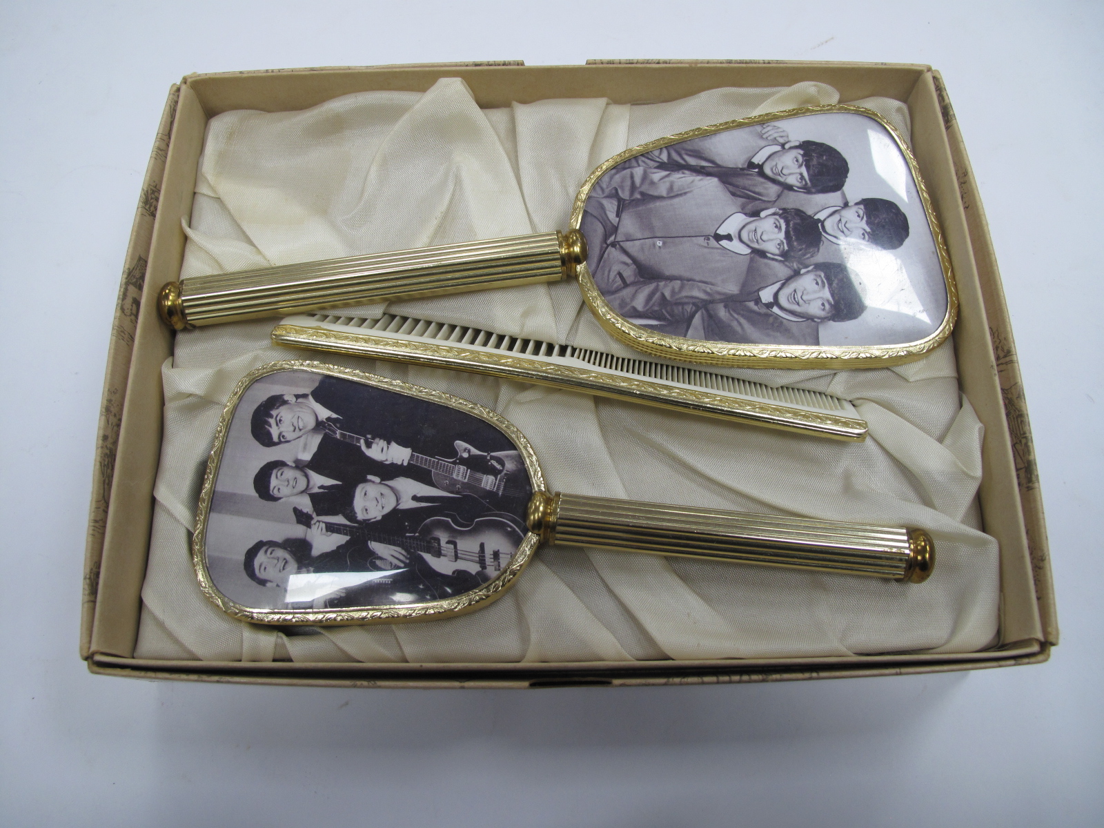 The Beatles Boxed Vanity Set, the backs of hand mirror and brush featuring images of The Fab 4.