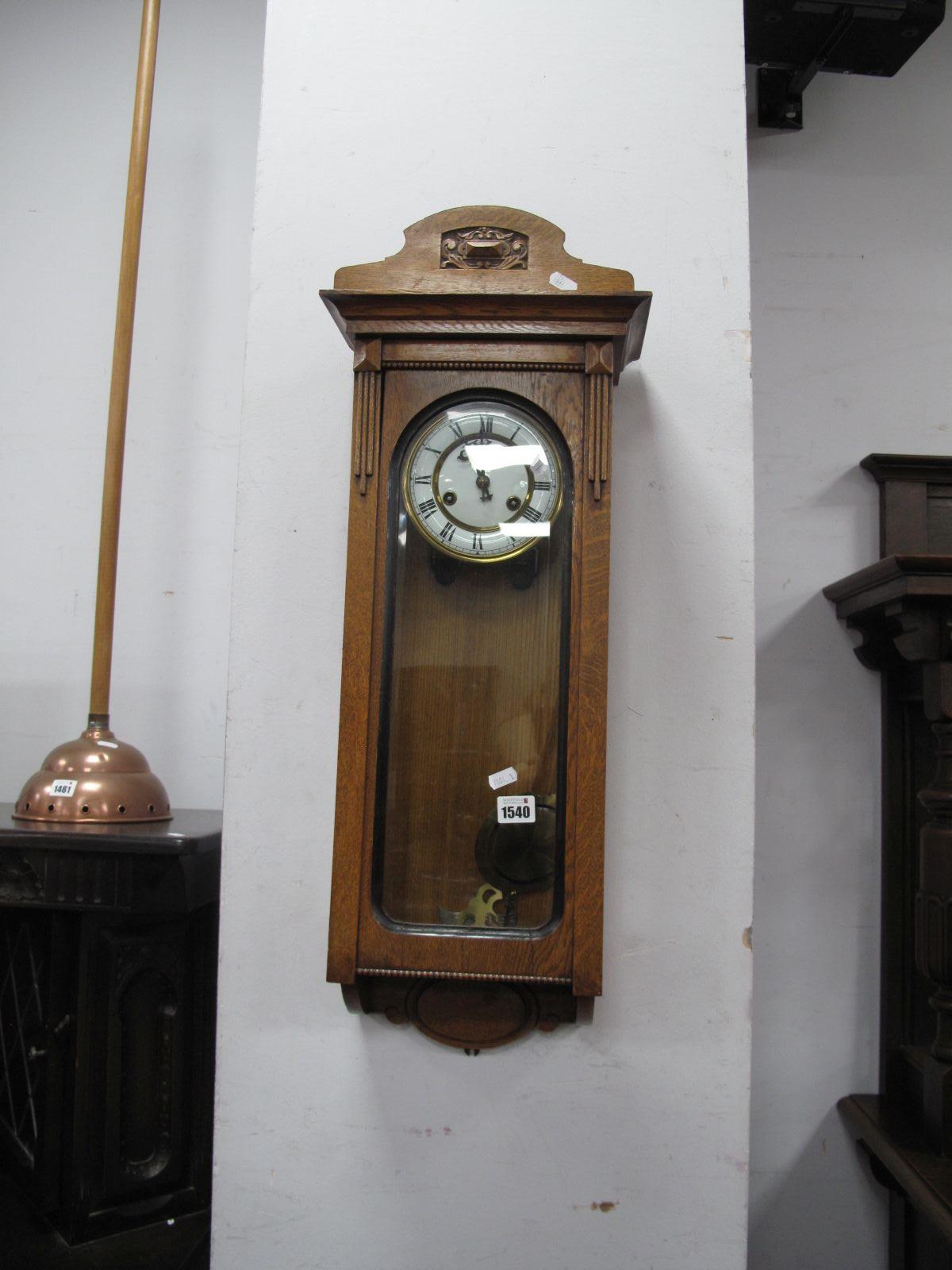 An Early XX Century Oak Wall Clock, white enamel, Roman numerals, glazed door and sides.