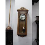 An Early XX Century Oak Wall Clock, white enamel, Roman numerals, glazed door and sides.