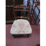 An Early XX Century Walnut Nursing Chair, with a shaped top rail, turned spindles, upholsted seat,