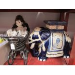 A Pottery Elephant, garden seat 43cm high, doll in pram. (2)