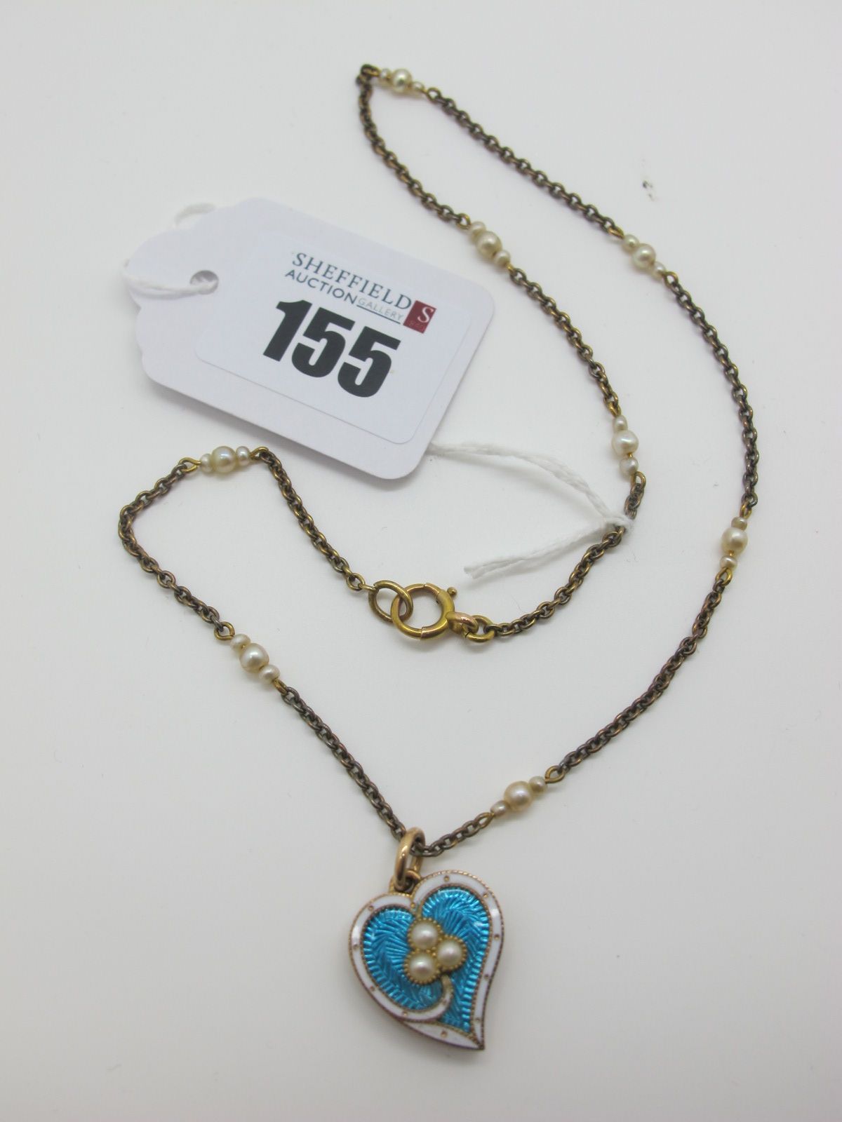 A Pearl Set Heart Shape Locket Pendant, highlighted in turquoise and white enamel, the glazed