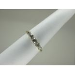 A Five Stone Diamond Ring, the graduated old cut stones claw set, between plain tapering