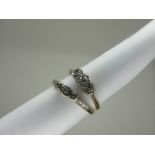 A Three Stone Diamond Ring, illusion set with single cut stones, stamped "18ct" "Plat" (finger