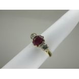 An 18ct Gold Ruby and Diamond Three Stone Ring, oval four claw set to the centre (wear to stone),