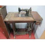 Gritzner Treadle Sewing Machine, in oak cabinet.